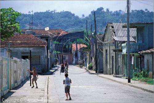 CUBA - Baracoa - la prima citt fondata sull'isola da Diego Velazquez tra il 1510 e il 1511 - scorcio in una via periferica con un bambino che gioca con un aquilone