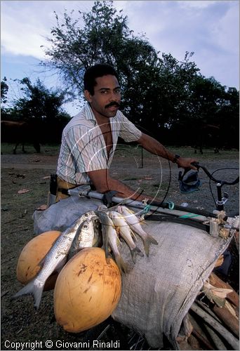 CUBA - (Baracoa) - un pescatore in bicicletta con il suo raccolto presso Porto Santo