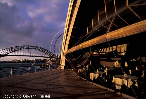 AUSTRALIA - SYDNEY - il raffinato ristorante dentro l'Opera House e sullo sfondo l'Harbour Bridge al tramonto