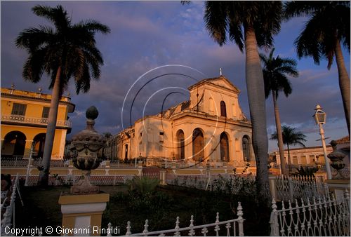 CUBA - Trinidad - Plaza Mayor, la piazza terrazzata con giardini, palme, inferriate, lampioni e vasi in ceramica - dietro  visibile la cattedrale