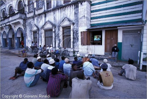 TANZANIA - ZANZIBAR  (Oceano Indiano) - Stone Town - guardando la televisione sotto all'edificio Bharmal